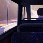 A view from the back seat of a bus, looking out at a winding road and rocky cliffs.