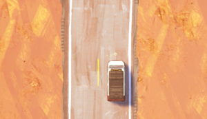 A top-down view of a white truck driving on a winding road through a desert landscape.