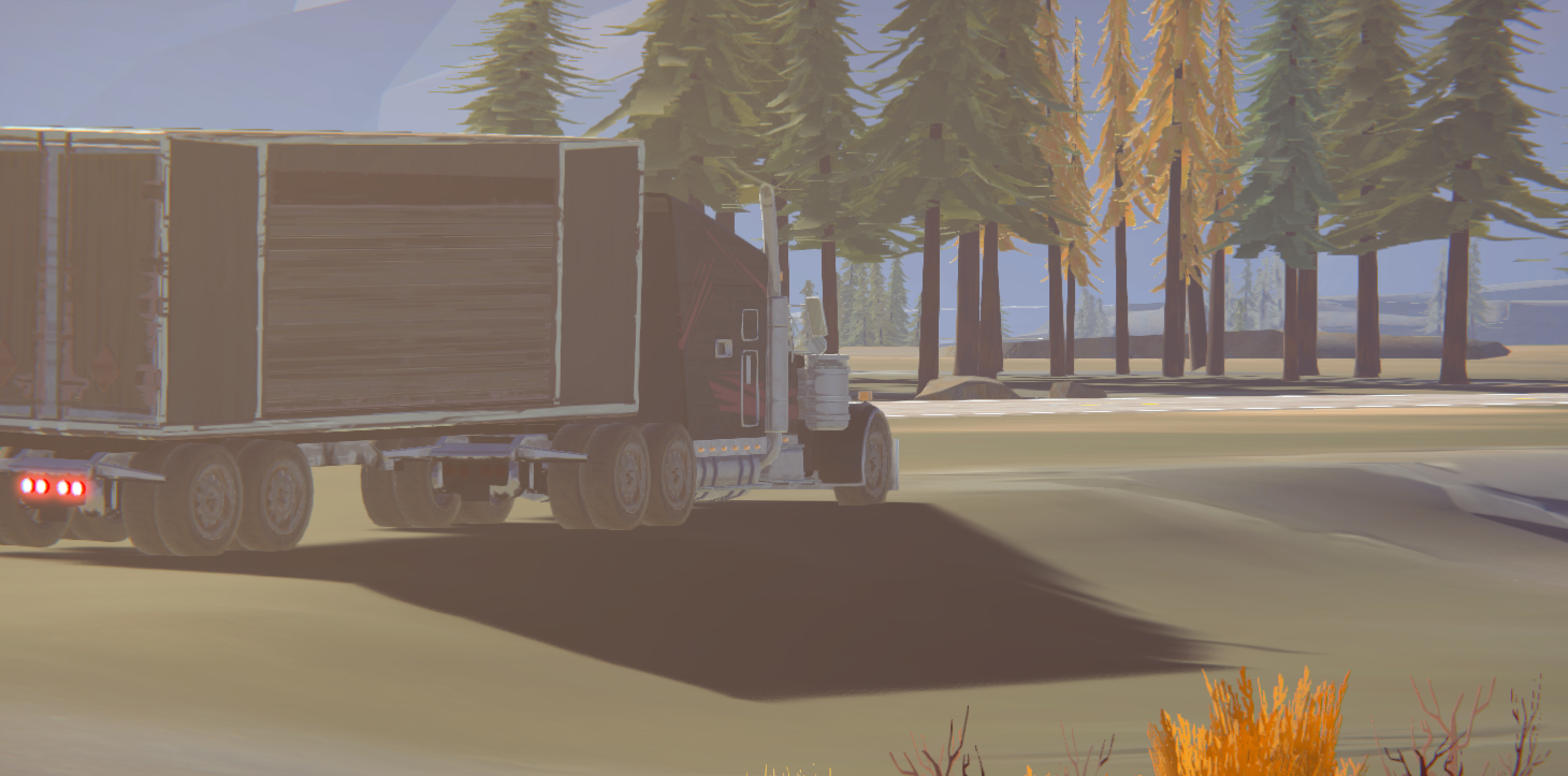 A truck driving through a scenic landscape with trees and a body of water in the background.