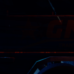 Close-up of a truck with the logo "GMT Transportation" in a dark, blue-lit environment.