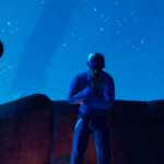 Three characters in stylized clothing are gathered around a rocky area under a starry night sky in the game Road 96.