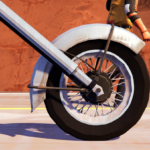 Close-up of a motorcycle wheel on a road with a desert backdrop.